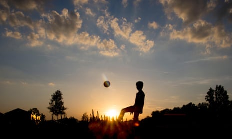 Silhouette of a teenage boy playing football