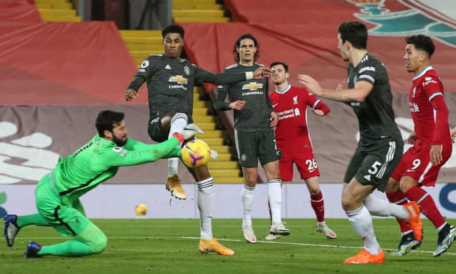 The Liverpool goalkeeper, Alisson, gets to the ball ahead of Manchester United’s Marcus Rashford.