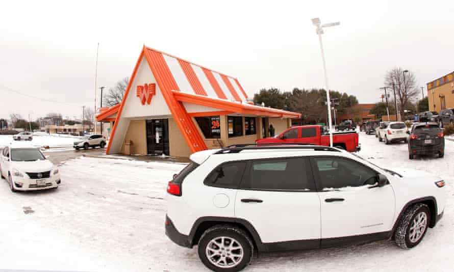 Cars wrap around a Whataburger franchise as they line up to order food after the storm.