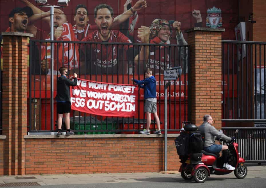 Deux supporters protestent contre le Fenway Sports Group à l'extérieur d'Anfield avant l'effondrement du projet de Super League.