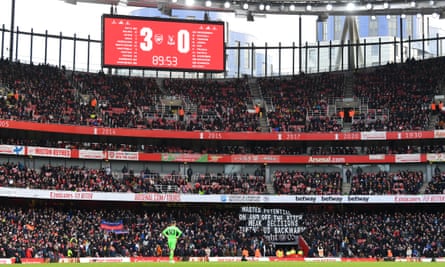 Dean Henderson looks on from the Crystal Palace goal as the banners express fans’ frustrations. Two Gabriel Martinelli goals in added time further soured their mood.