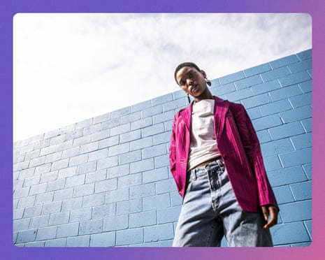 Portrait of fashionable young woman in front of bright blue wall