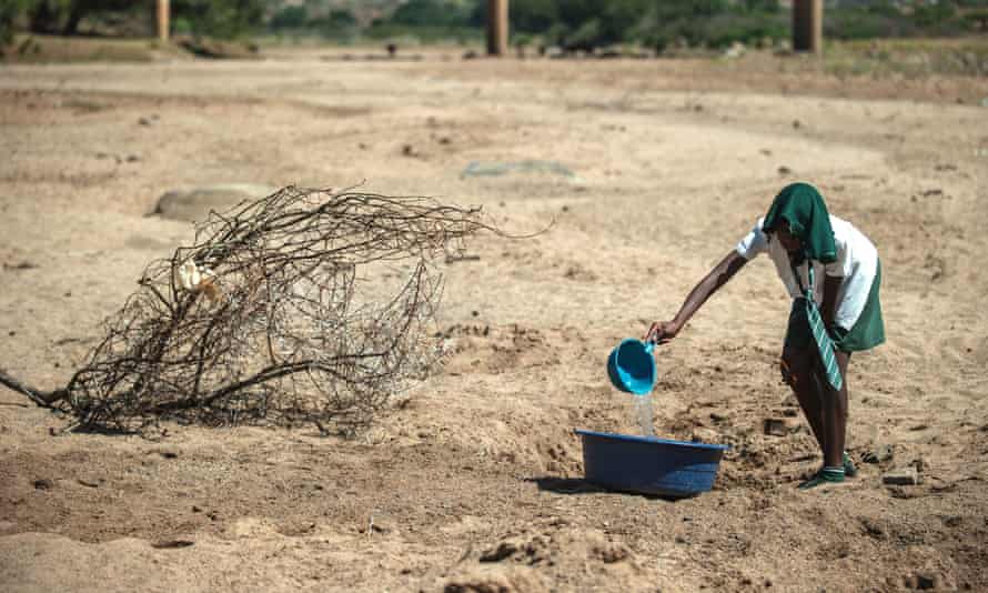 A shool girl tries to collect water from a dry puddle in Nongoma, north west of Durban, that has been badly affected by the recent drought.