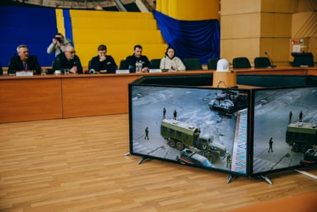 A committee watches archival videos of the Russian occupation in 2022 in Chornobyl.