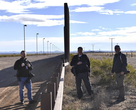 Photographers Jim Watson, Yuri Cortez and Guillermo Arias at metal fence between the US and Mexico in Puerto Palomas