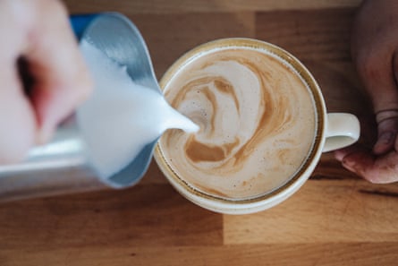 Person pouring milk into coffee