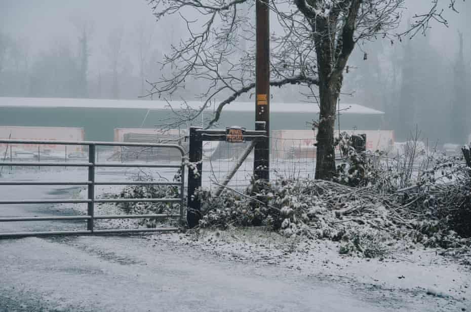 A snow-covered gated property with a private property sign
