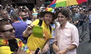 Trudeau poses for a photo as he greets spectators at the Toronto Pride parade.