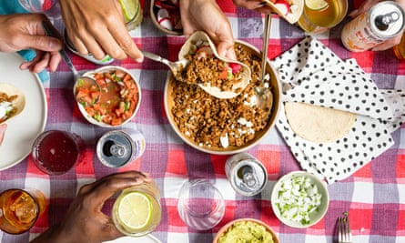 An overhead view of diverse hands eating from dishes.