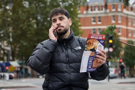Gecsoyler orders a takeaway on the phone with a takeaway menu in his other hand