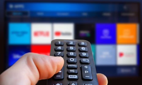 A man holding a remote control of a smart TV