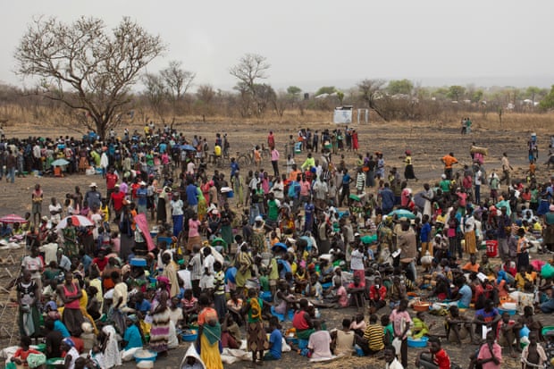 Hundreds of refugees massed on a bare plain 