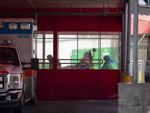 A private ambulance team brings in a probable COVID-19 patient to the emergency room of the Elmhurst Hospital Center in the Queens borough of New York City.