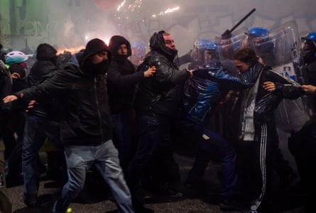 Demonstrators with police in riot gear