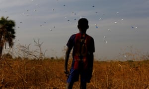 A boy watches sacks of food drop to the ground during a United Nations World Food Programme airdrop close to Rubkuai village in Unity State, northern South Sudan, in February 2017.