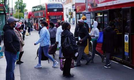 People are seen getting on and off a bus in Brixton, London