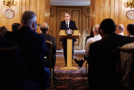 Starmer speaking at a lectern in front of row oof seated people