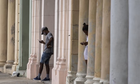 Cubans use their cell phones near to where a pre-paid public wifi connection was working near the Malecon seawall in Havana, earlier this month.