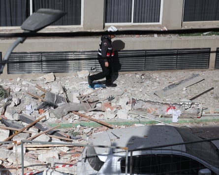 A firefighter inspects the damage caused to a block of flats by an Iranian cluster munition in Ramat Gan.