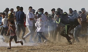 Volunteer paramedic Razan al-Najjar, 21, centre, is seen before being shot by Israeli troops while running to take cover from teargas.