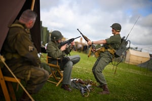 People dressed as US soldiers in the second world war aim guns