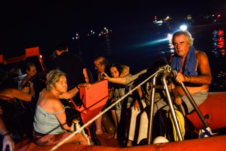 People evacuate from the village of Mati on Monday night