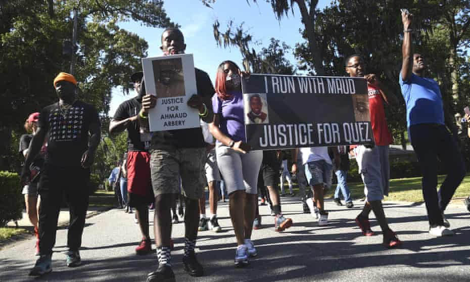 A crowd marches through a neighborhood in Brunswick, Georgia, demanding answers in the death of Ahmaud Arbery. 