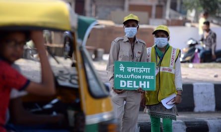 Volunteers stand with placards at a junction in Delhi to raise awareness of odd-even number plate car restrictions.