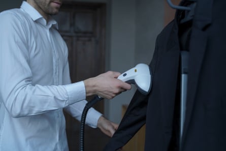 Man cleaning his suit with steamer