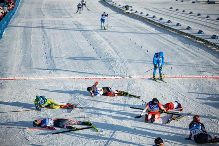Competitors collapse at the finish line after the women’s skiathlon on Saturday.