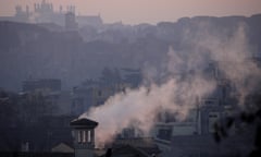 Smoke billows from chimneys of residential buildings in Rome.