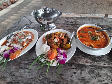 Closeup of several dishes of food laid out on a wooden table