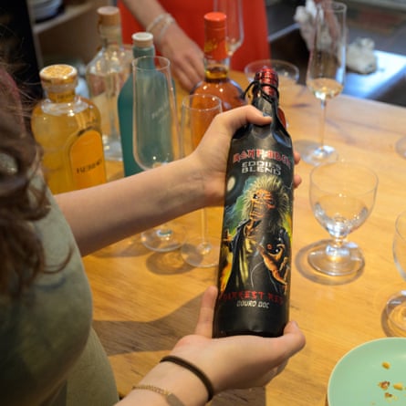 Hands hold a bottle of the Iron Maiden Darkest red wine