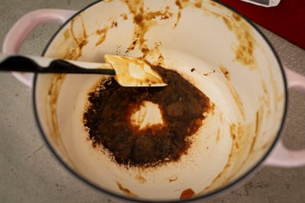 The burned remains of a curry on the bottom of an Aldi cassarole dish.