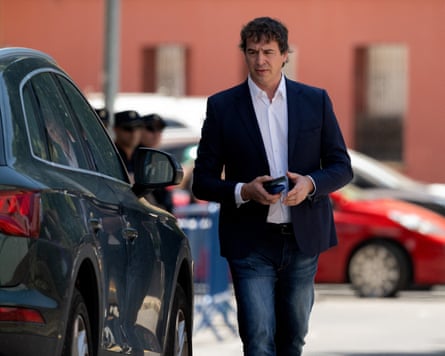 David Sánchez walks towards a car in front of the Badajoz courthouse. He is tall with dark hair and in his early 50s. He wears a dark blue jacket, white shirt and jeans.