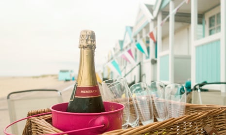 Bottle of champagne and champagne flute in picnic basket, Southwold, Suffolk, UK.