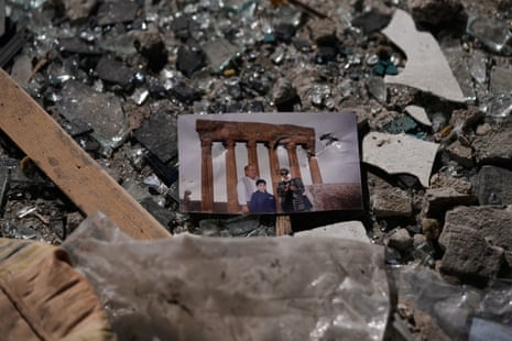 A photo showing a man, woman and child on top of rubble.