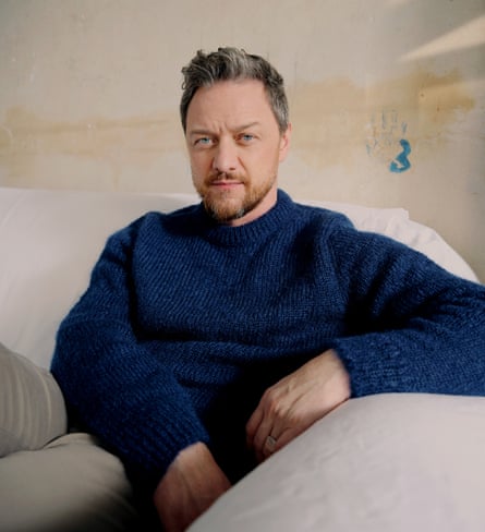 James McAvoy, sitting on a pale sofa, in dark blue mohair sweater