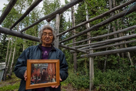 Woman holding photo of salmon fillets hanging from a wooden frame