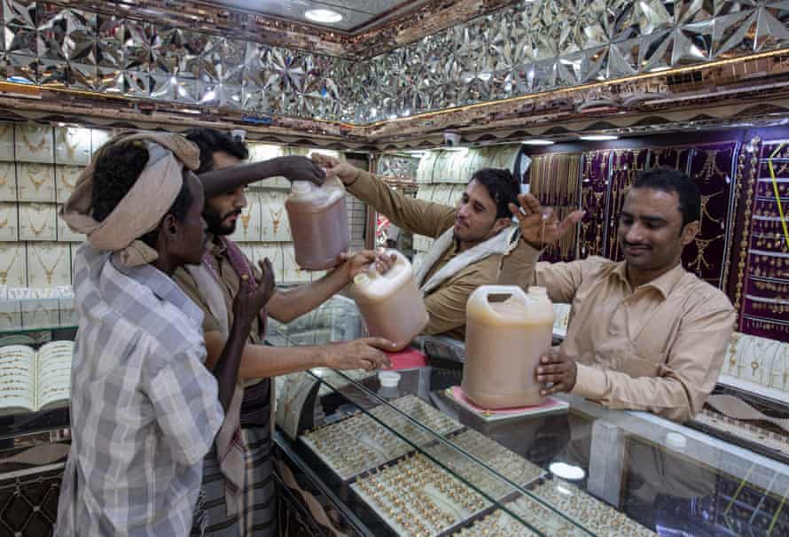 Honey sellers allow workers to sample their wares in a jewellery shop in Ataq, Shabwah governorate.