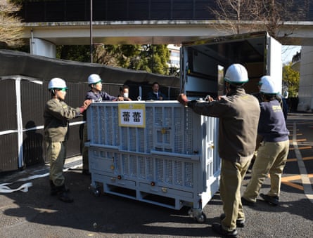 People in hard hats standing around a crate
