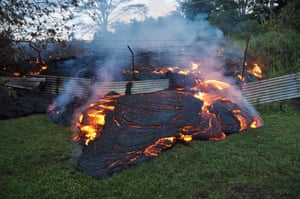 Lava pushes through a fence marking a property boundary