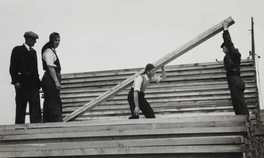 hombres levantando un largo trozo de madera