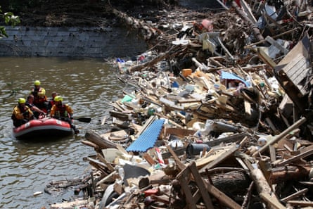 Rescuers in a dinghy look for survivors in Trooz, Belgium, after serious flooding in July 2021