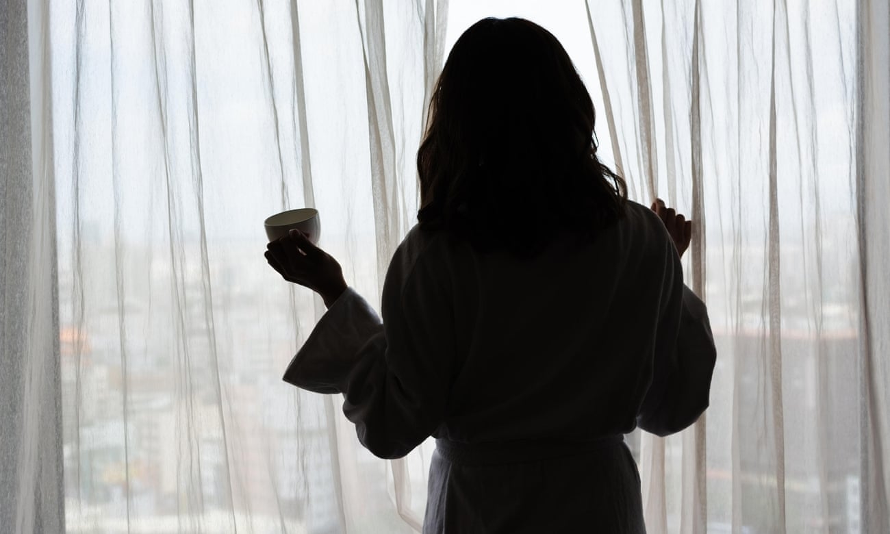 Silhouette of a woman standing in front of a window.