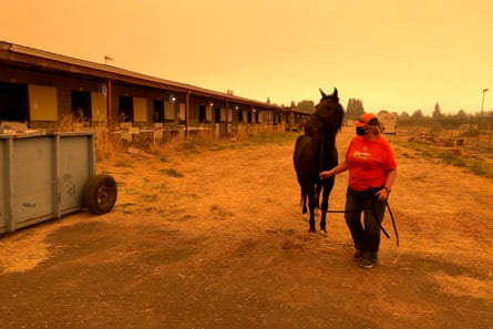 Catherine Shields leads her horse Takoda on the Oregon State Fairgrounds under eerie smoky skies in Salem, Oregon. Shields evacuated her horse and other animals to the fairgrounds as wildfires threatened.