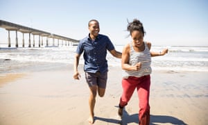 Playful couple running on sunny beach