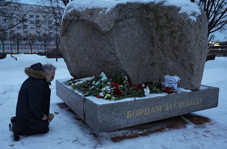 A man kneels at the monument to victims of political repression in Saint Petersburg, Russia.