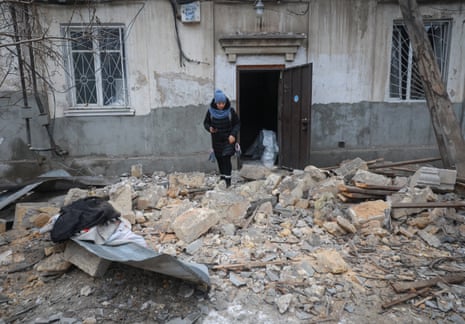 A woman walks among the rubble after following the drone strike.