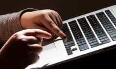 A child's fingers typing on a computer keyboard